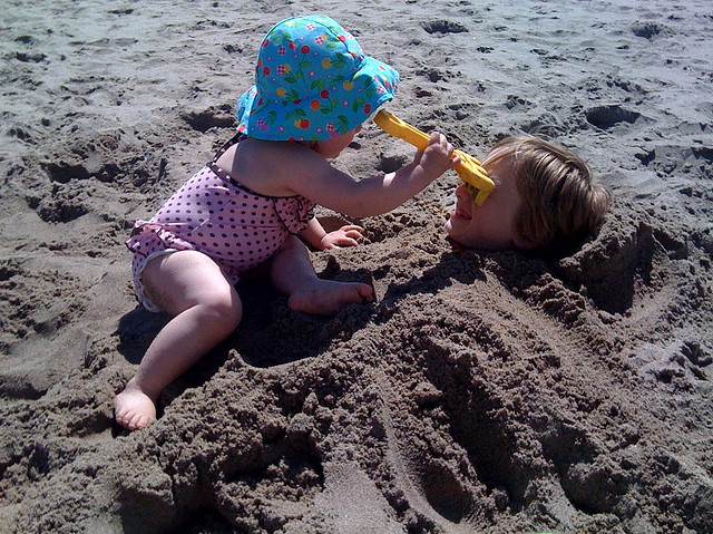 sis bury brother in sand